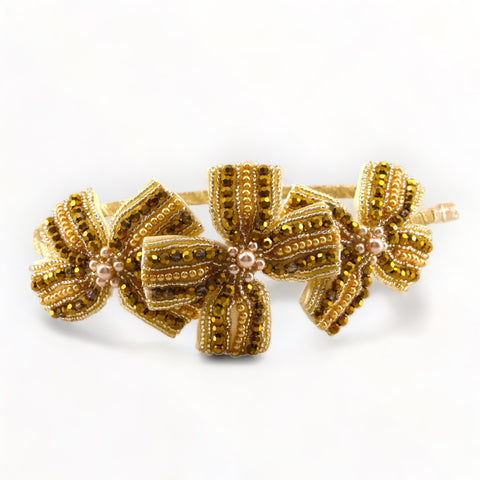 Buy the best Designer Childrens gold bow accessories.  The Jolie Headband is entirely handmade with sparkling gold crystals and pearls.  Perfect luxury kids party and special occasionwear hair band.