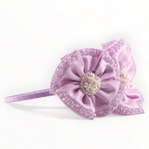 Buy best designer girls headband.  The Angelina is entirely hand made with lilac satin and hand stitched and embelished with sparkling crystal beads and pearls for elegance.  Perfect for a childs special occasion outfit.