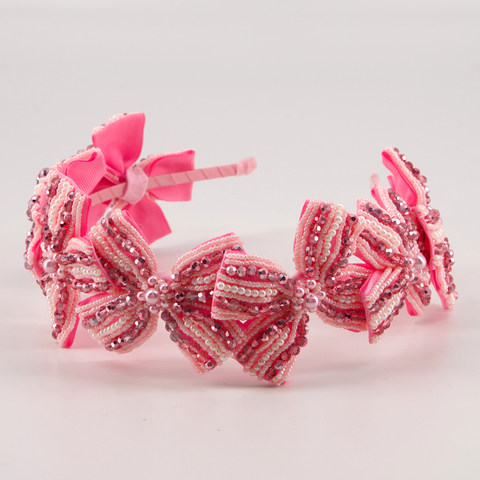 Buy the best luxury handmade hair accessories for children.  This entirely hand stitched beaded bow headband in pink is highly embelished and perfect for celebration wear.